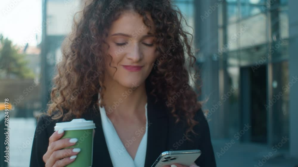 Close up Caucasian woman smiling businesswoman female walking drinking coffee in city happy cheerful business girl hold smartphone scrolling social media online chatting mobile phone drink go outdoors