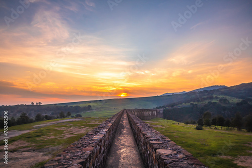 Aqueduct between mountains at sunrise with cloudy sky in arcos del sitio in tepotzotlan state of mexico photo