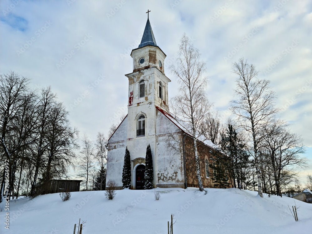 An old small church on snow-covered hill in the Latvian village of Remte in December 2021