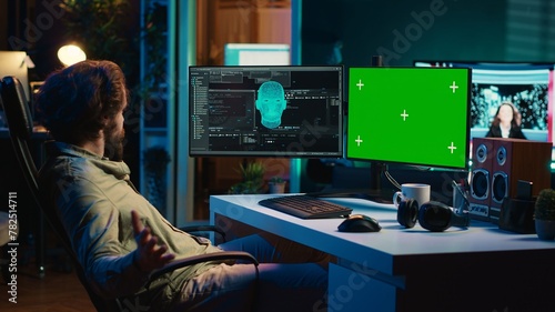 Programmer being asked existential questions by awaken AI on mockup PC gaining consciousness. Man communicating with artificial intelligence through green screen computer, camera A © DC Studio