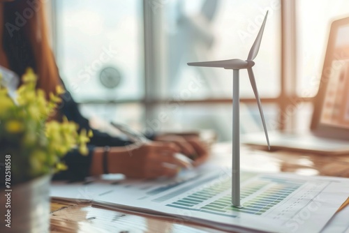 An eco-friendly miniature wind turbine on a work desk, symbolizing sustainable energy practices photo