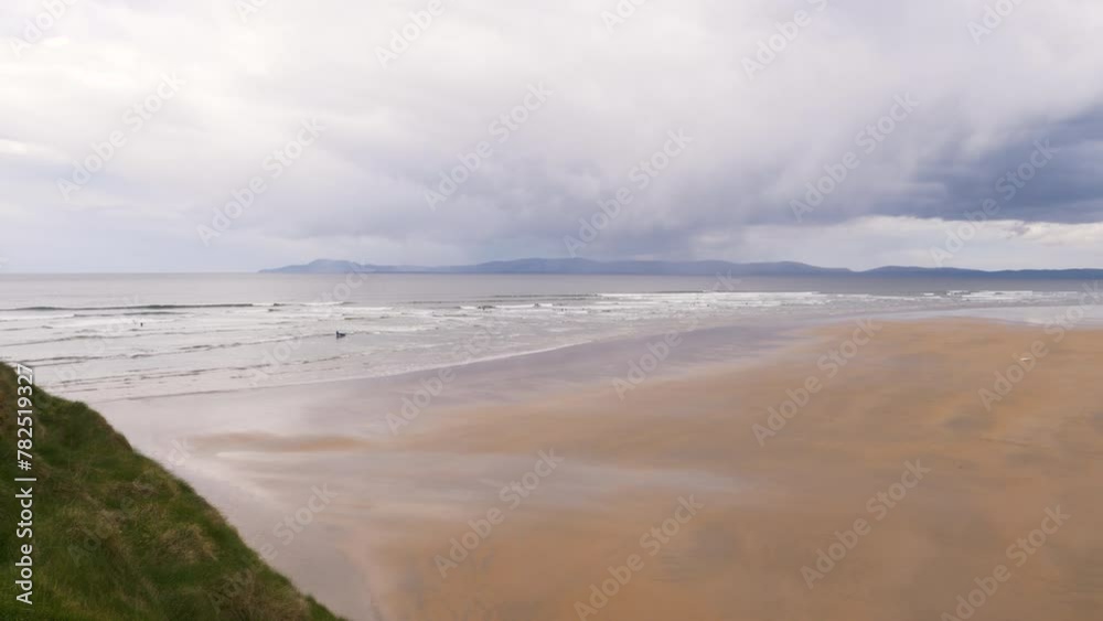A purple reflection on the golden sand on an overcast day, choppy sea. Tullan Strand, Bundoran, Co. Donegal, Ireland