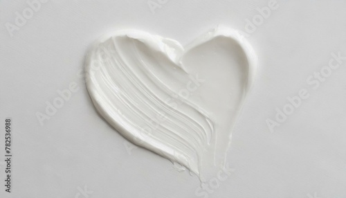 White beauty skincare cream swipe smear in heart shape on white Background. Cosmetics makeup smudge swatches. Top view
