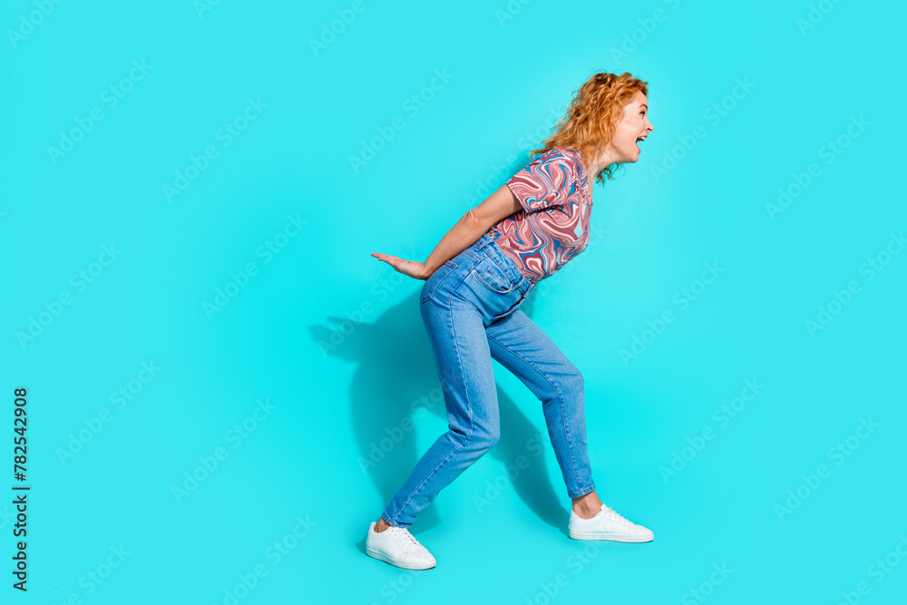 Full length portrait of nice lady hands hold empty space wear t-shirt isolated on teal color background Full length portrait of nice lady hands hold empty space wear t-shirt isolated on teal color background