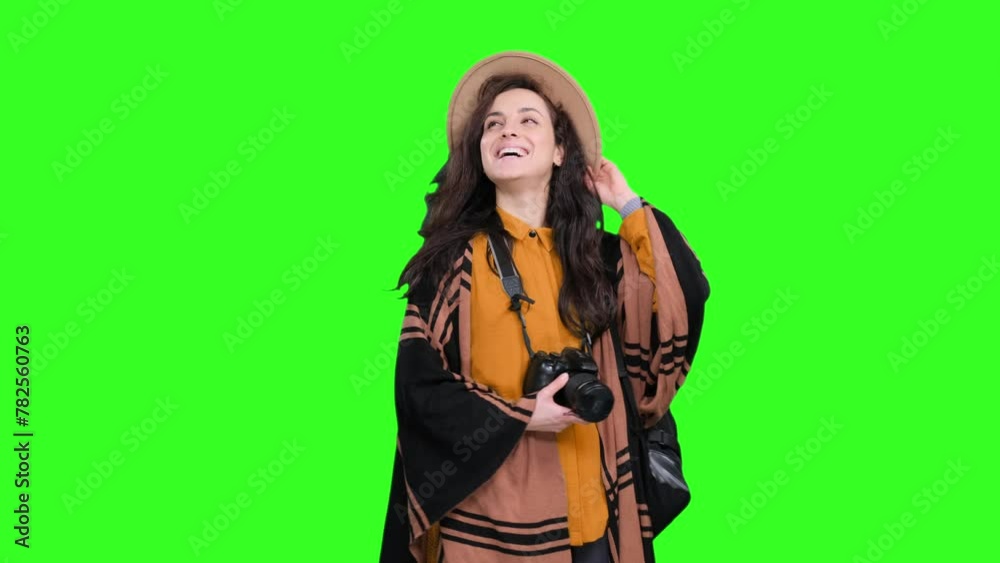 Happy woman walking during trip and holding camera on the chroma key Happy woman walking during trip and holding camera on the chroma key