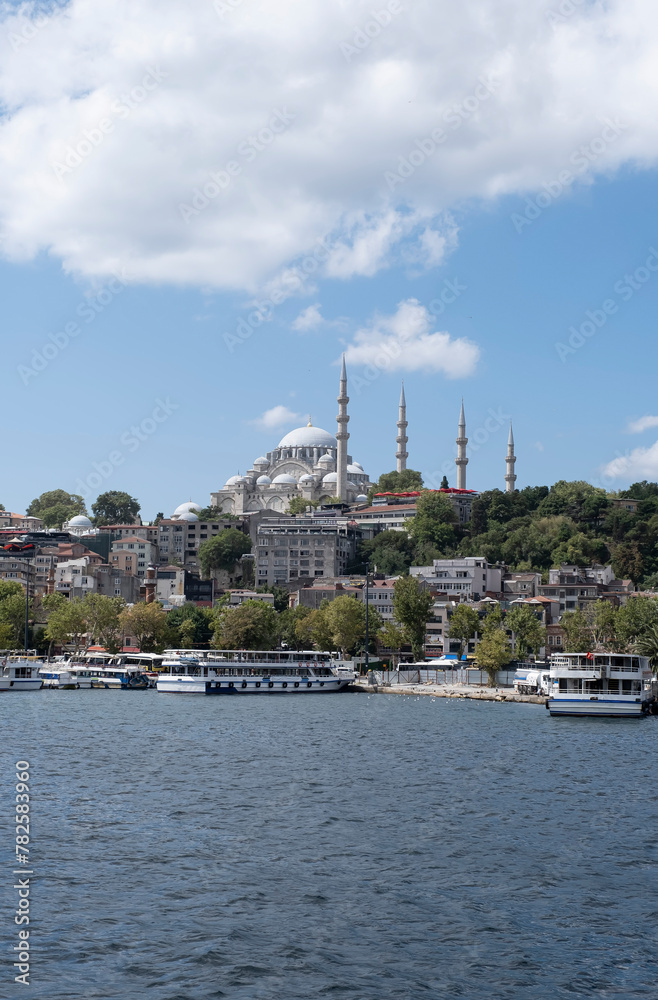 skiline of the city of Istanbul, with the Suleymaniye Mosque seen from the bosporus, sailboat over the Bosphorus, Suleiman mosque