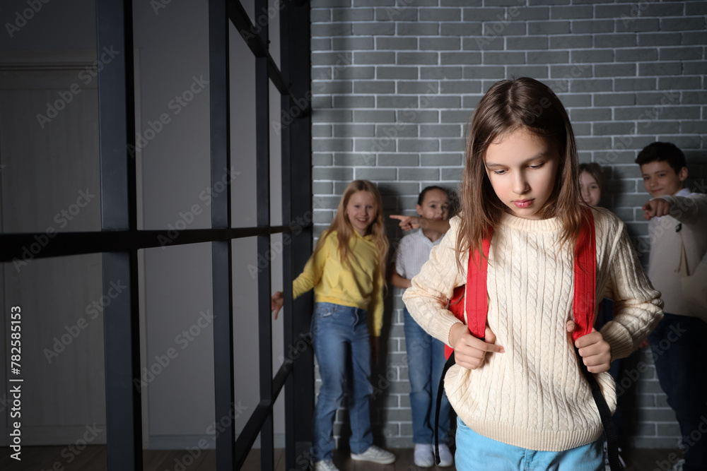 Bullied little girl with backpack at school - obrazy, fototapety, plakaty 