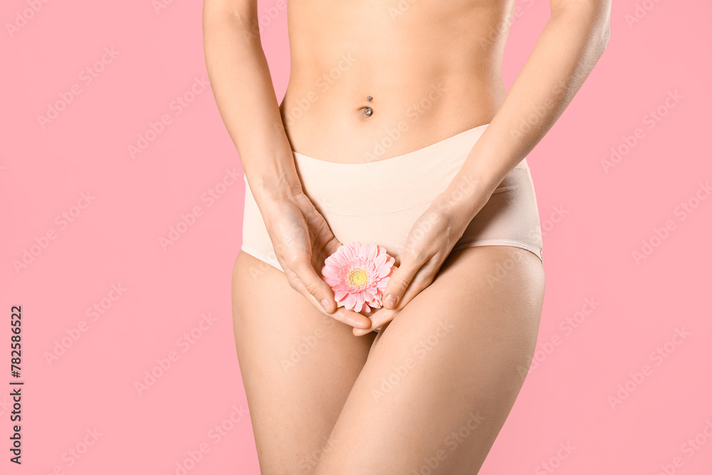Young woman in panties with beautiful flower on pink background - obrazy, fototapety, plakaty 