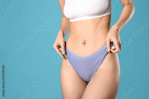 Young woman in panties on blue background © Pixel-Shot