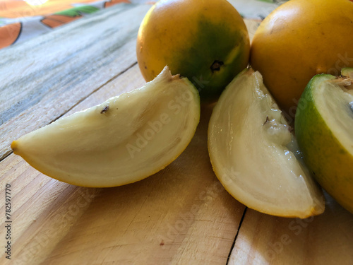 Abiu fruit cut on rustic wooden board ready for consumption photo