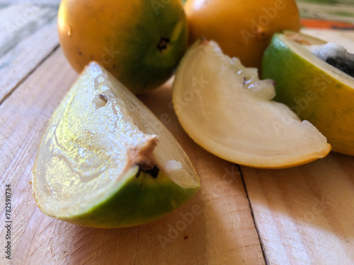 Abiu fruit cut on rustic wooden board ready for consumption photo