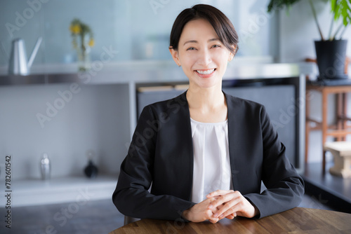 スーツ姿で笑顔で話すカメラ目線の女性のビジネスシーン　士業やコンサルタント不動産などのイメージ photo