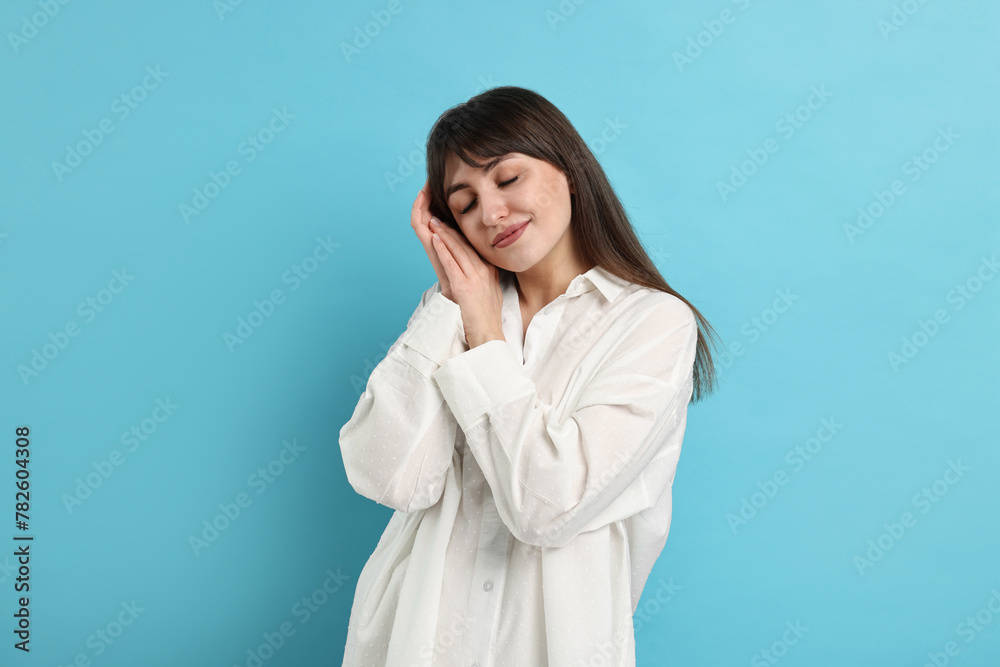 Woman in pyjama sleeping on light blue background Woman in pyjama sleeping on light blue background
