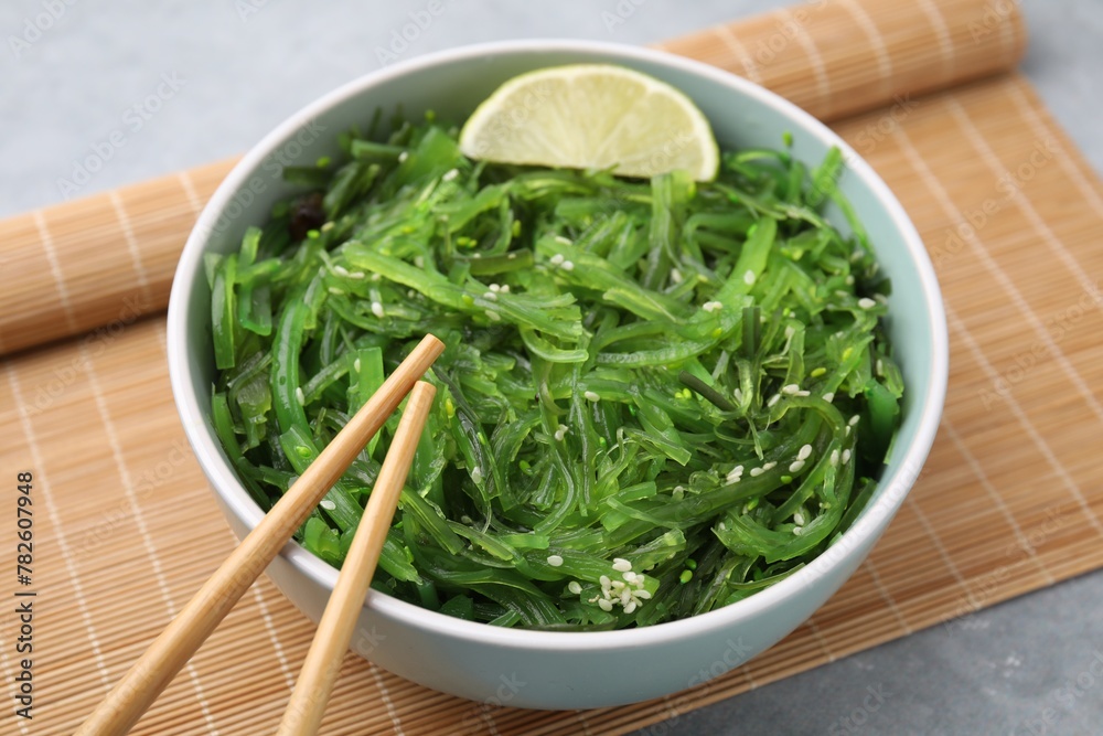 Tasty seaweed salad in bowl served on gray table, closeup Tasty seaweed salad in bowl served on gray table, closeup