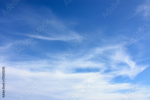 Tranquil beauty of wispy white clouds drifting across the clear azure sky, painting a mesmerizing and serene scene on a perfect sunny day, evoking a sense of peace and wonder in the heart. photo
