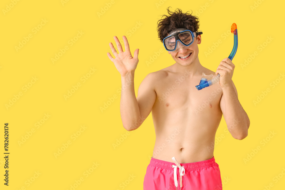 Handsome young happy man with snorkeling mask on yellow background Handsome young happy man with snorkeling mask on yellow background