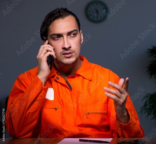 Young convict man sitting in dark room