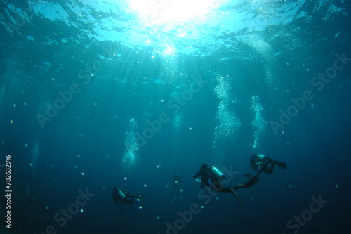 泡をあげて深海を潜るダイバー