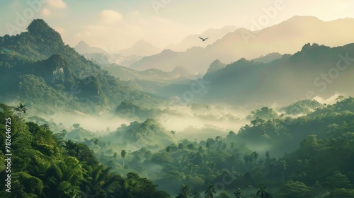 A panoramic view of a mountain forest bathed in the soft light of dawn after a night of rain. Mist hangs low over the valley, slowly revealing the majestic peaks cloaked in lush greenery. A lone bird  photo