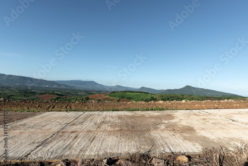 Side view of concrete road in countryside with mountains.