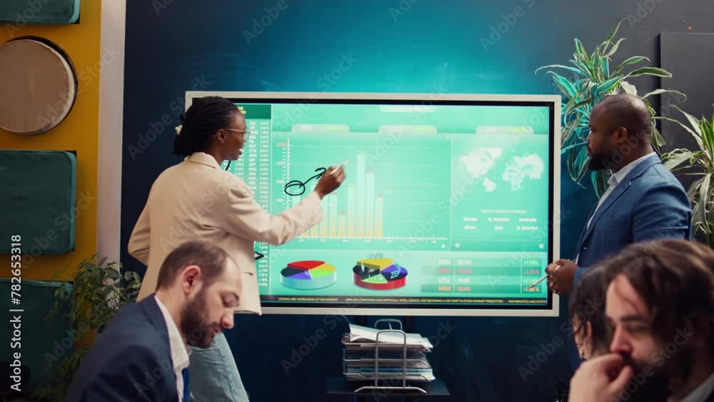 Financial analysts team evaluating market trends and infographics, reviewing business intelligence strategies to leverage data insights for decision making purposes. Accounting group. Camera B.