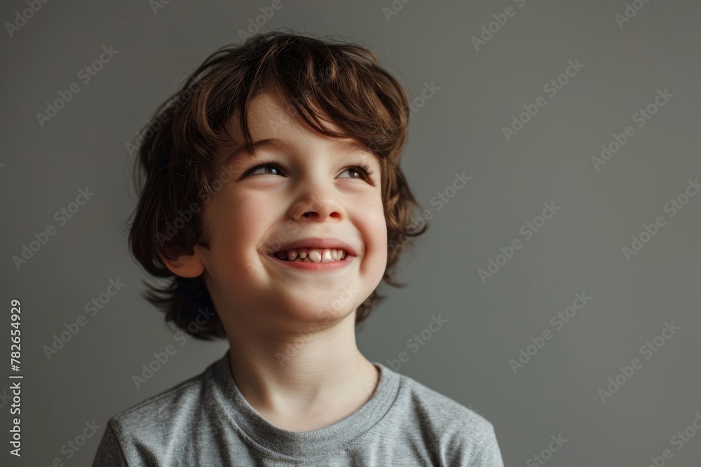 Portrait of a smiling little boy on a gray background. Happy kid. Portrait of a smiling little boy on a gray background. Happy kid.