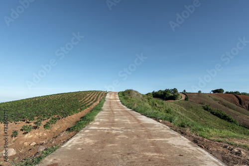 Concrete road in countryside with mountains.