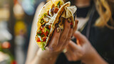 woman holding a mexican taco about to eat it