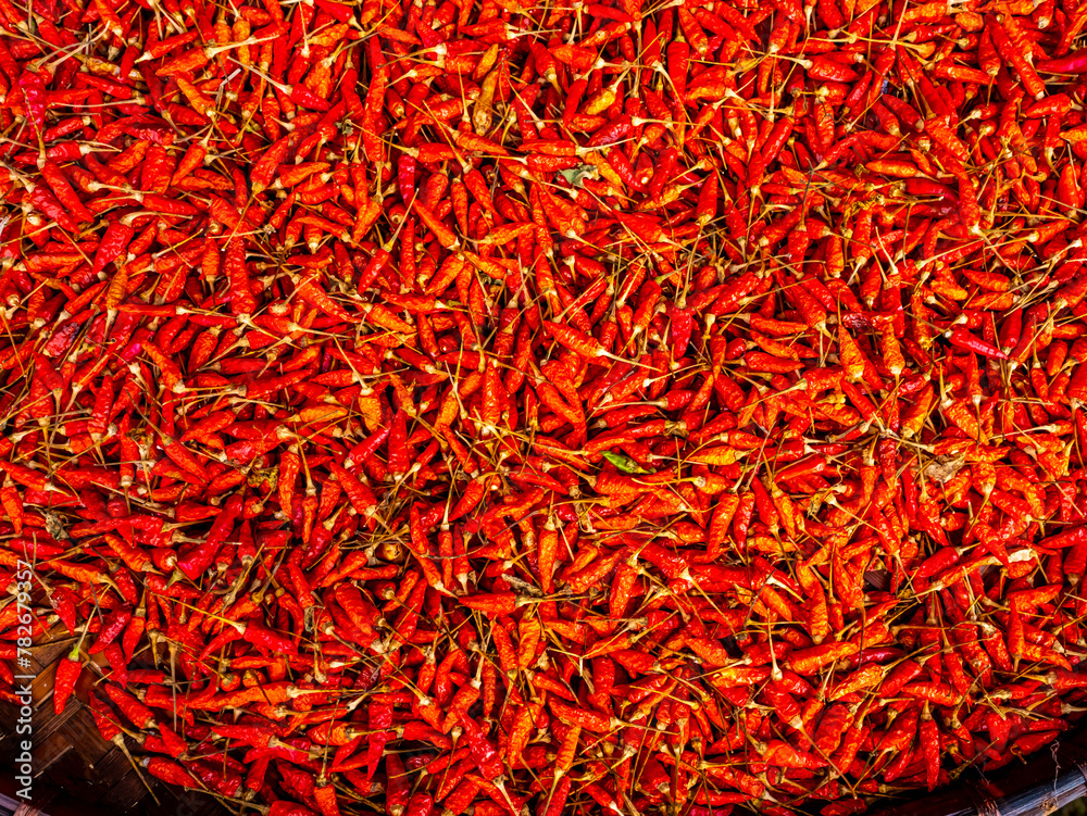 Dry red chili on threshing basket left to dry on the sun. Traditional asian food preservation, it is used extensively in Thailand. Dry red chili on threshing basket left to dry on the sun. Traditional asian food preservation, it is used extensively in Thailand.