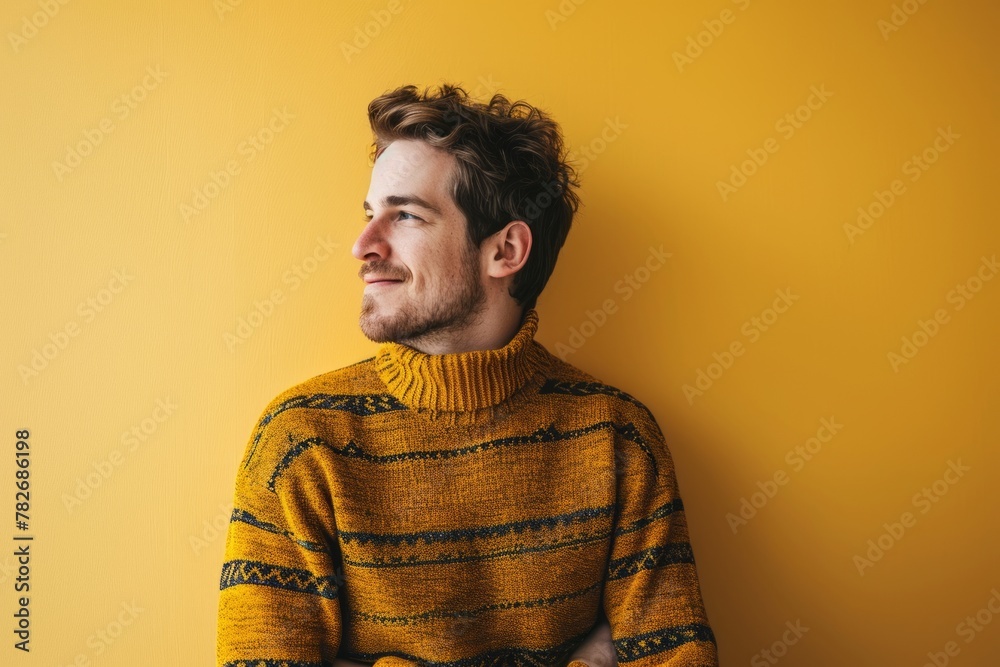 Portrait of a handsome young man in sweater on yellow background. Portrait of a handsome young man in sweater on yellow background.