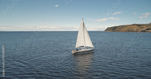 Slow motion aerial of yacht sail. Sun reflect at sea water. Nobody nature seascape. Sport and recreation. Marine vacation. Business cruise tour to South America. Luxury sailboat cross Atlantic ocean