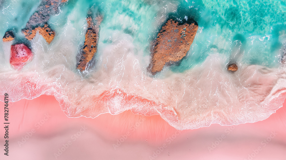 An aerial shot capturing the gentle clash of turquoise waves against a pastel pink sandy shore.