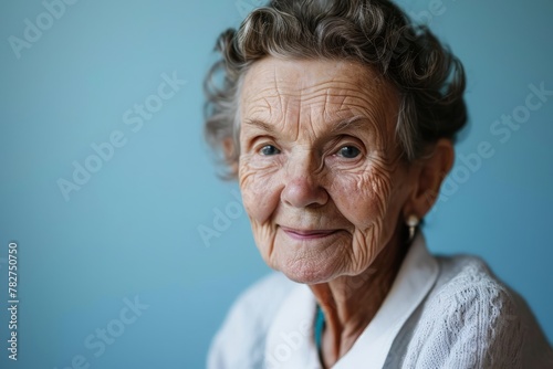 Portrait of smiling senior woman on blue background. Focus on face.