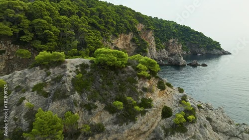 Kalamota Island, Adriatic Sea, Croatia - The Stunning Vista of the Island's Rugged, Vegetated Cliffs and Clear Blue Waters - Aerial Pullback Shot
