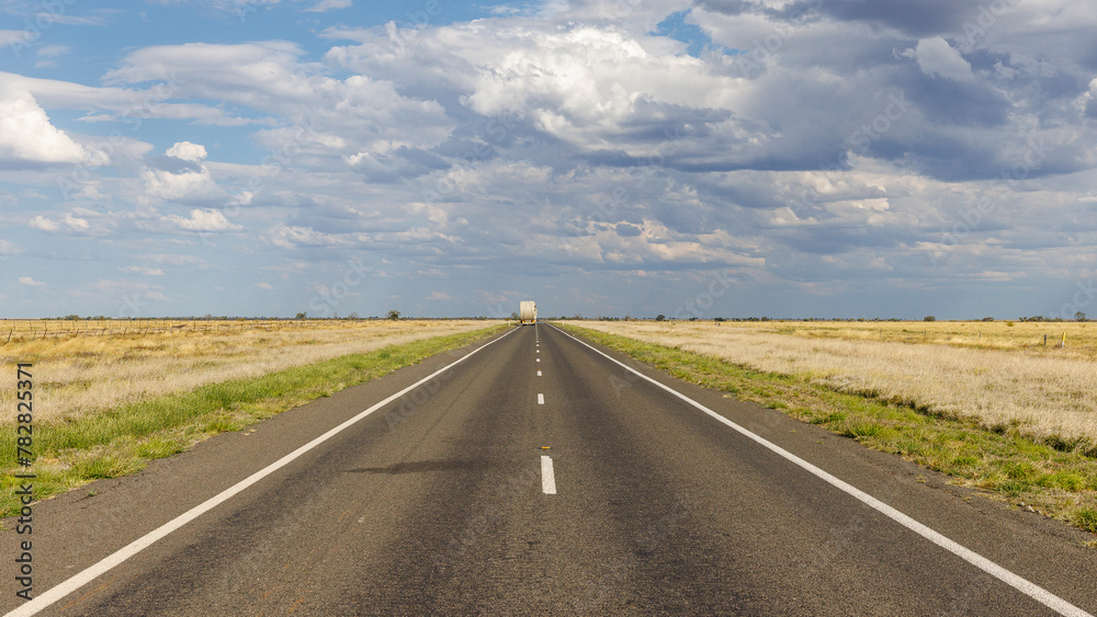 Straight line on Matilda highway under a cloudy sky, Queensland, Australia