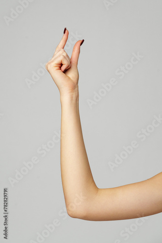 Young woman hand gesture on gray background