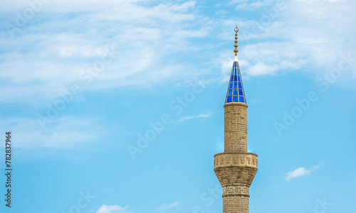 Foto Mosque minaret with blue glass in front of a sunny, cloudless blue sky