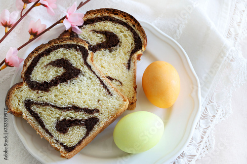 Cozonac, pane dolce tradizionale rumeno con noci e due uova di Pasqua isolate su sfondo bianco. Concetto di vacanza di Pasqua.