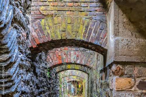 Rundbogen historisches Mauerwerk aus Backsteinen an einem Durchgang zwischen historischer Stadtmauer und Eisenbahn photo