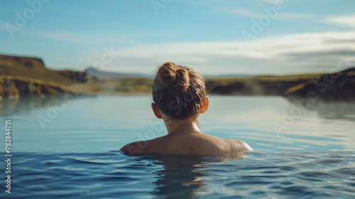 Young woman enjoying spa in hot springs in iceland