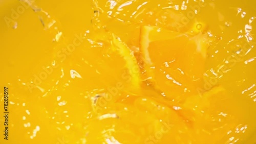 close up of natural orange slices falling in juice, advertising of tropical fruit juice splashing, super slow motion photo