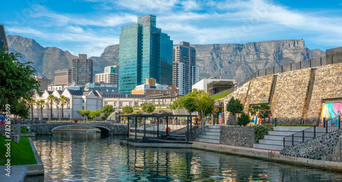 A canal in the marina district of Cape Town, with the city center skyline and Table mountain in the background, South Africa photo