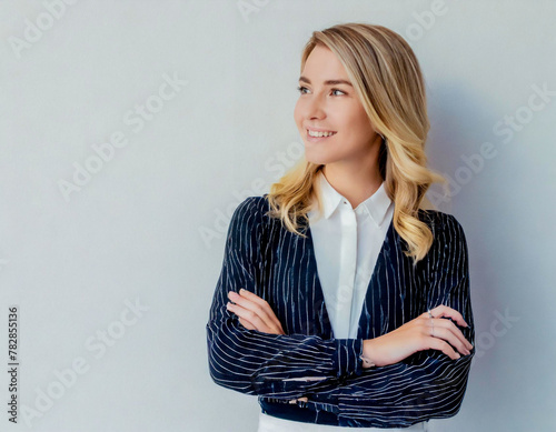 Young woman portrait blonde girl arms crossed over grey wall background smiling looking aside