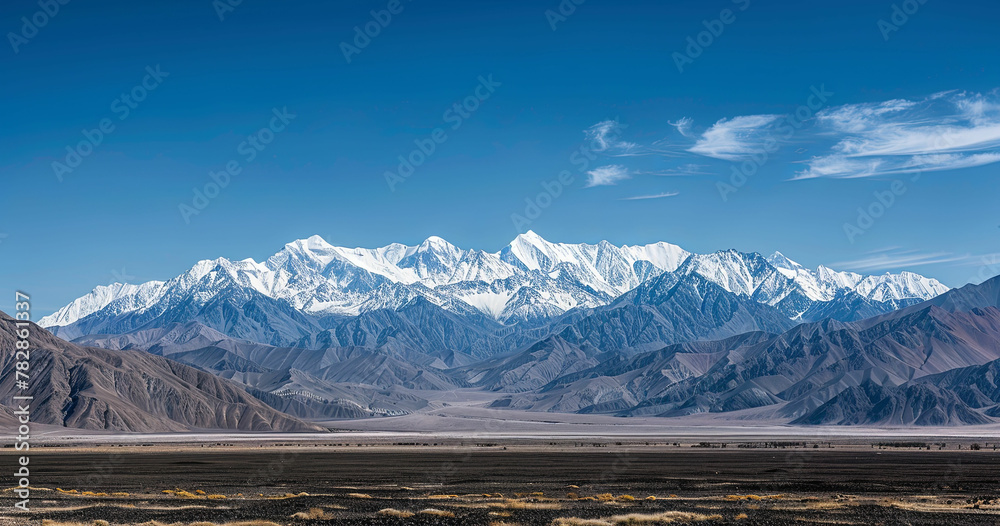 a mountain range with snow capped mountains in the background