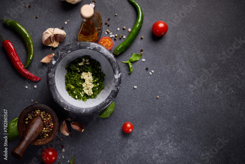 stone mortar with green sauce chopped ingredients