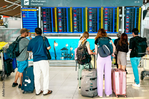 Принти на полотні Group of travelers, adorned with backpacks and luggage, stands before an airport