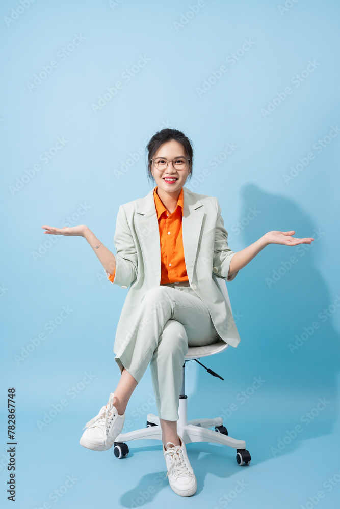 Obraz premium Photo of young Asian businesswoman on blue background