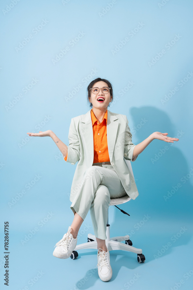 Obraz premium Photo of young Asian businesswoman on blue background