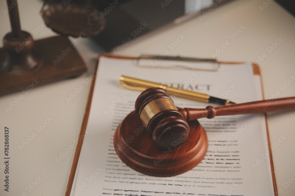 image of judge's hammer, scales lady of justice, law book, laptop computer and contract documents with pen concept of law and justice.