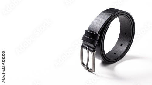 Twisted black leather belt with matted metal buckle isolated on white background. Fastened fashionable unisex, man or woman accessory for trousers, jeans, dress. Male luxury strap. Haberdashery goods
